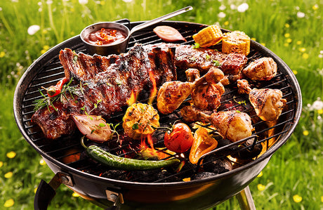 Würzige Spareribs und Hähnchenstücke brutzeln auf einem Grill bei direkter Hitze – bereit für das perfekte BBQ.