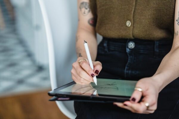 Eine Frau malt auf einem Tablet mit einem Stift