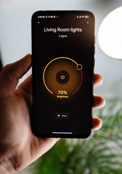 Ein Handy zeigt einen Dimm-Regler für die Lichter eines Wohnzimmers