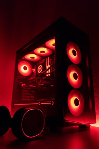Ein PC in dunklem Zimmer mit rot leuchtenden Lüftern. 