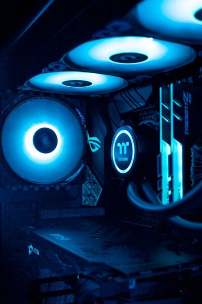 Ein PC in dunklem Raum mit blau leuchtenden Lüftern