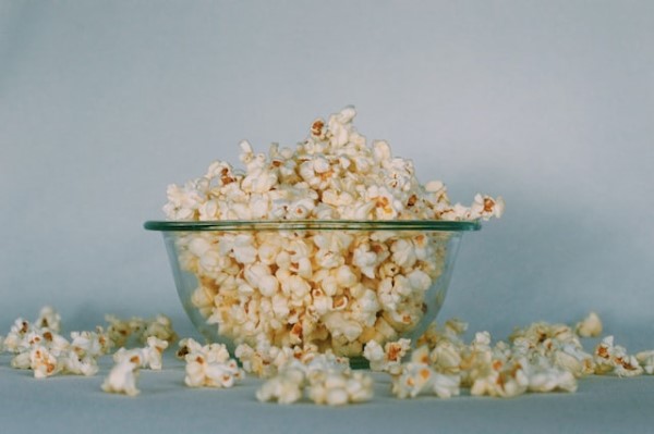 Eine Glasschüssel, die voller Popcorn überquillt.