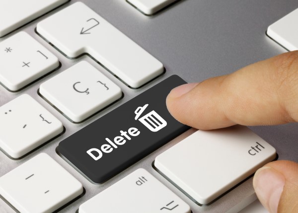 Eine Person drückt auf einer Laptop-Tastatur auf den "Delete"-Knopf.