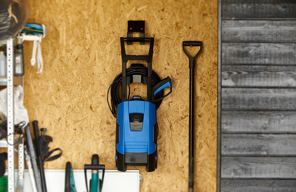 Hochdruckreiniger hängt in einer Garage oder Schuppen aufgeräumt an der Wand